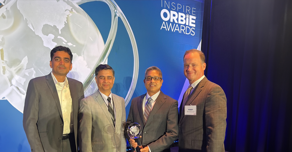 Nik Umrani and Dan Pijawka standing with the ORBIE Award