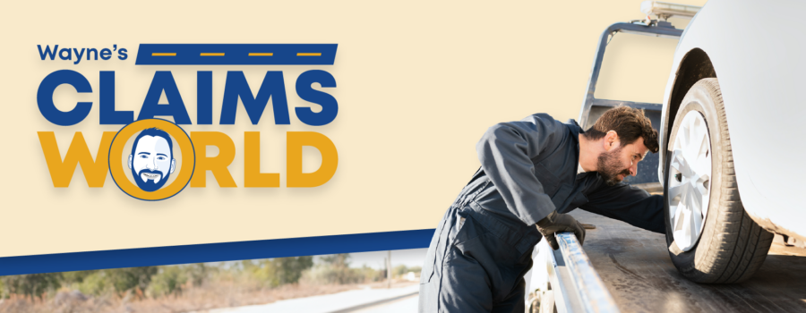 Wayne’s Claims World logo, photo of tow truck operator loading a car on a tow truck