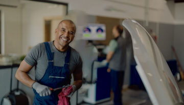 Auto mechanic next to car in auto shop