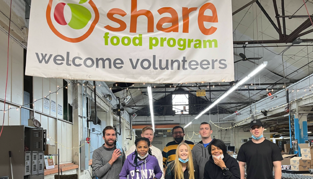 Photo of several people volunteering at a food bank`